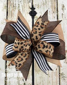 a leopard print bow with black and white stripes on the front, sitting on top of a pole