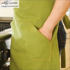 a person wearing an apron is opening the oven door with their hand in his pocket