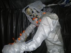 a white shoe decorated with orange lights and skulls on the inside is sitting in a black plastic bag