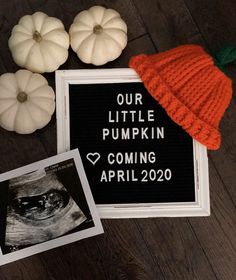 pumpkins and other decorations are on the floor next to a sign that says our little pumpkin is coming april 20