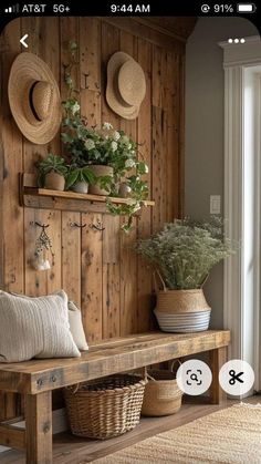 a wooden bench sitting next to a wall filled with plants and hats on top of it