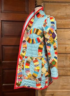 a quilted jacket hanging on a wooden door