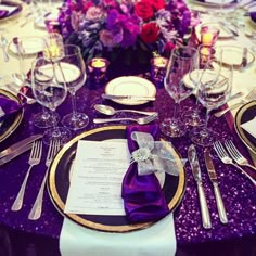 the table is set with silverware and purple napkins, along with an elegant centerpiece