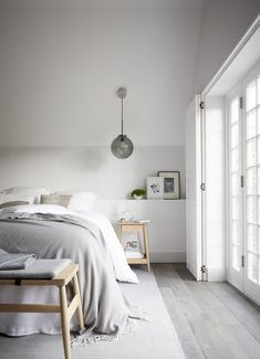 a bedroom with white walls and wood floors