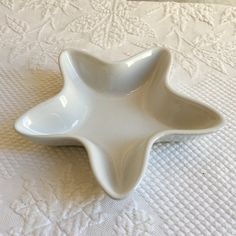 a white bowl sitting on top of a bed