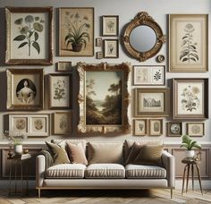 a living room filled with lots of framed pictures and paintings on the wall next to a couch