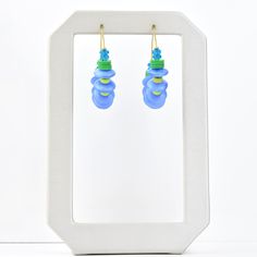 Made in the USA Brass hoops Kelly green, aqua and blue beads Earrings hang 1.5 inches Want to see more of this collection? David Aubrey lines vary from delicate, meticulously assembled jewelry of monochromatic hues to larger, more vibrant pieces. Some collections are themed, whether romantic, vintage, tribal, or art deco. Each piece is painstakingly crafted with an array of raw materials, including plated and oxidized brass and white metal, semiprecious stones, vintage glass beads, Indian handma Adjustable Blue Hoop Earrings With Dangling Beads, Blue Recycled Glass Dangle Earrings, Blue Recycled Glass Nickel-free Earrings, Blue Nickel-free Recycled Glass Earrings, Nickel-free Blue Recycled Glass Earrings, Adjustable Blue Jewelry Made Of Recycled Glass, Adjustable Blue Recycled Glass Jewelry, Adjustable Blue Jewelry With Recycled Glass, Blue Glass Jewelry With Dangling Beads