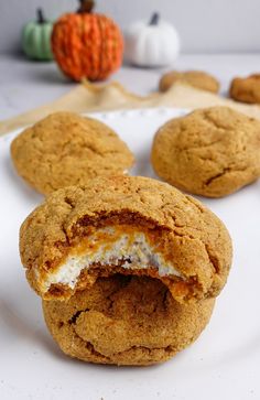 some cookies are on a white plate with pumpkins in the background