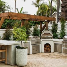 an outdoor kitchen with grill and seating area