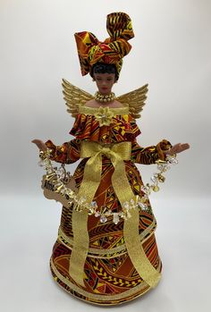 a figurine is dressed in an orange and yellow dress with gold trimmings