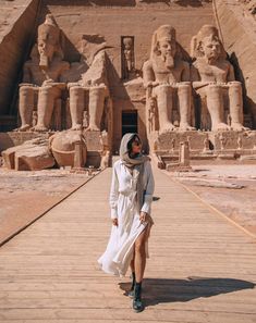 a woman standing in front of an egyptian temple