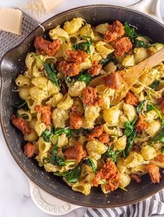 a skillet filled with pasta and sausage