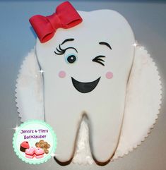 a tooth shaped cake with a red bow on it