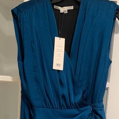 a blue dress with a black shirt underneath it and a tag on the back that says,