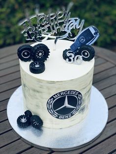 a birthday cake decorated with monster trucks and wheels