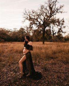 a pregnant woman sitting in the middle of a field