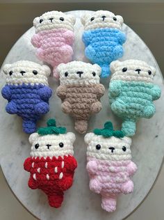 six crocheted teddy bears sitting on top of a white plate