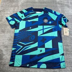 a t - shirt with an abstract design on the front and blue, black, and white colors