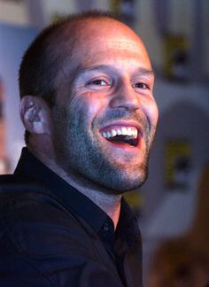 a man smiling and wearing a black shirt