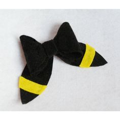 a black and yellow bow tie laying on top of a white surface with no background