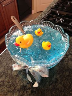 two rubber ducks in a glass bowl on a counter