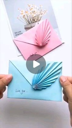 two hands holding up an envelope with folded paper