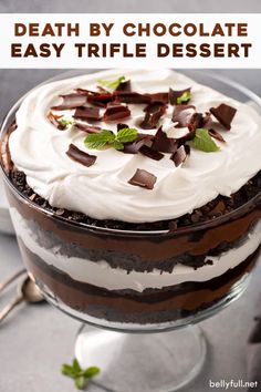 a close up of a cake with white frosting and chocolate pieces on top in a glass dish