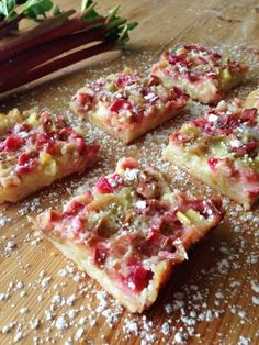 several pieces of pizza sitting on top of a wooden table next to radishes