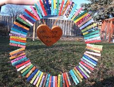 a person holding up a heart made out of books in front of a fence with the words we are making fun written on it