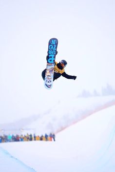 a man flying through the air while riding a snowboard