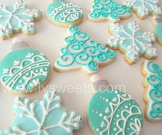 decorated christmas cookies with blue and white icing on a table top, ready to be eaten