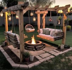 an outdoor fire pit with swings and chairs