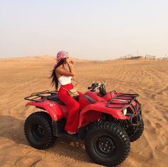 a woman is riding an atv in the desert