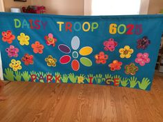 a child is standing in front of a banner that says daisy troop