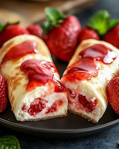 two strawberry cheesecakes on a black plate with strawberries in the foreground