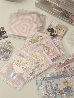 some anime stickers are laying out on a table with other items in the background