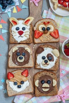 several slices of bread with fruit on them and faces made to look like cats, dogs, and bears