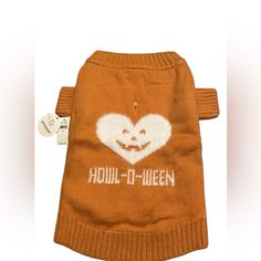 an orange sweater with a white heart on the front and words haddil - e - ween written across the chest