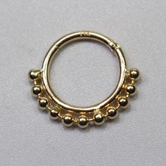 a gold colored ring with balls on it