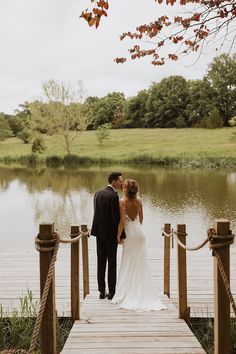 a bride and groom standing on a dock