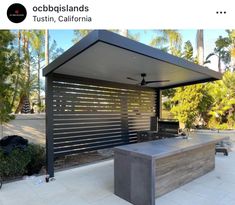 an outdoor kitchen with a grill on the outside, and a covered patio area behind it