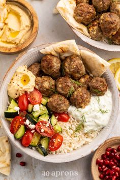 two bowls filled with meatballs, rice and veggies on top of a table