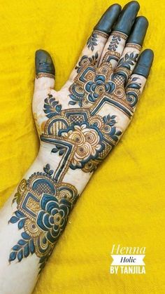 the hand is decorated with blue and gold henna designs on it's palm