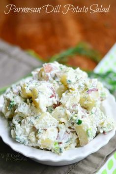 a white bowl filled with potato salad sitting on top of a green and white napkin