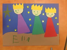 a child's handmade card with three children wearing crowns and stars on it