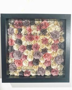 a black frame with pink, yellow and grey flowers in it