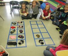 a group of children sitting on the floor in front of a game