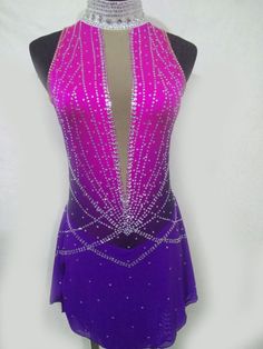 a woman's purple and pink figure skating dress with sequins on it