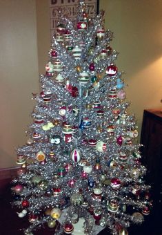 a silver christmas tree with ornaments on it