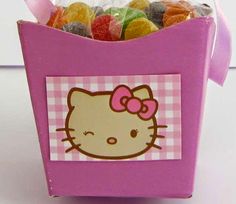 a pink hello kitty candy box filled with gummy bears and candies in it